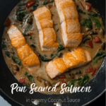 pan seared salmon fillets in pan on coconut sauce