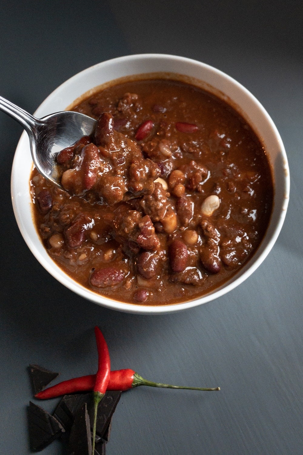 Smoky Chili con Carne in a bowl with a chili and chocolate decoration