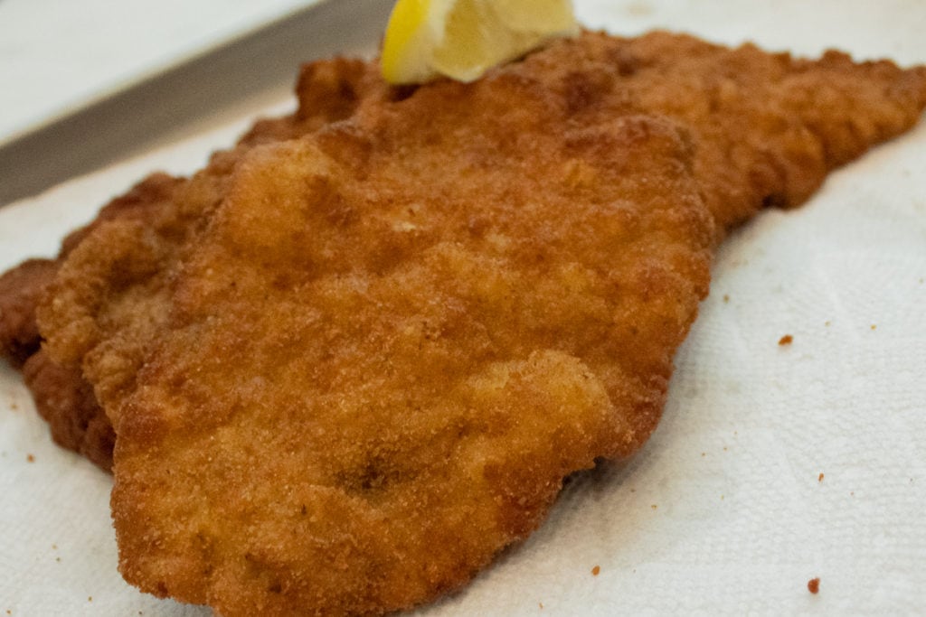 Multiple fried Schnitzel on kitchen paper towel to remove excess fat