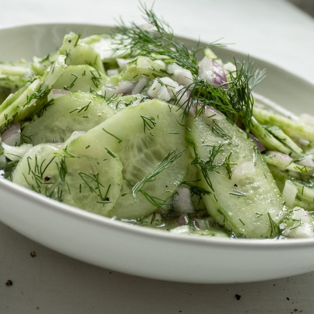 a bowl of cucumber salad with dill