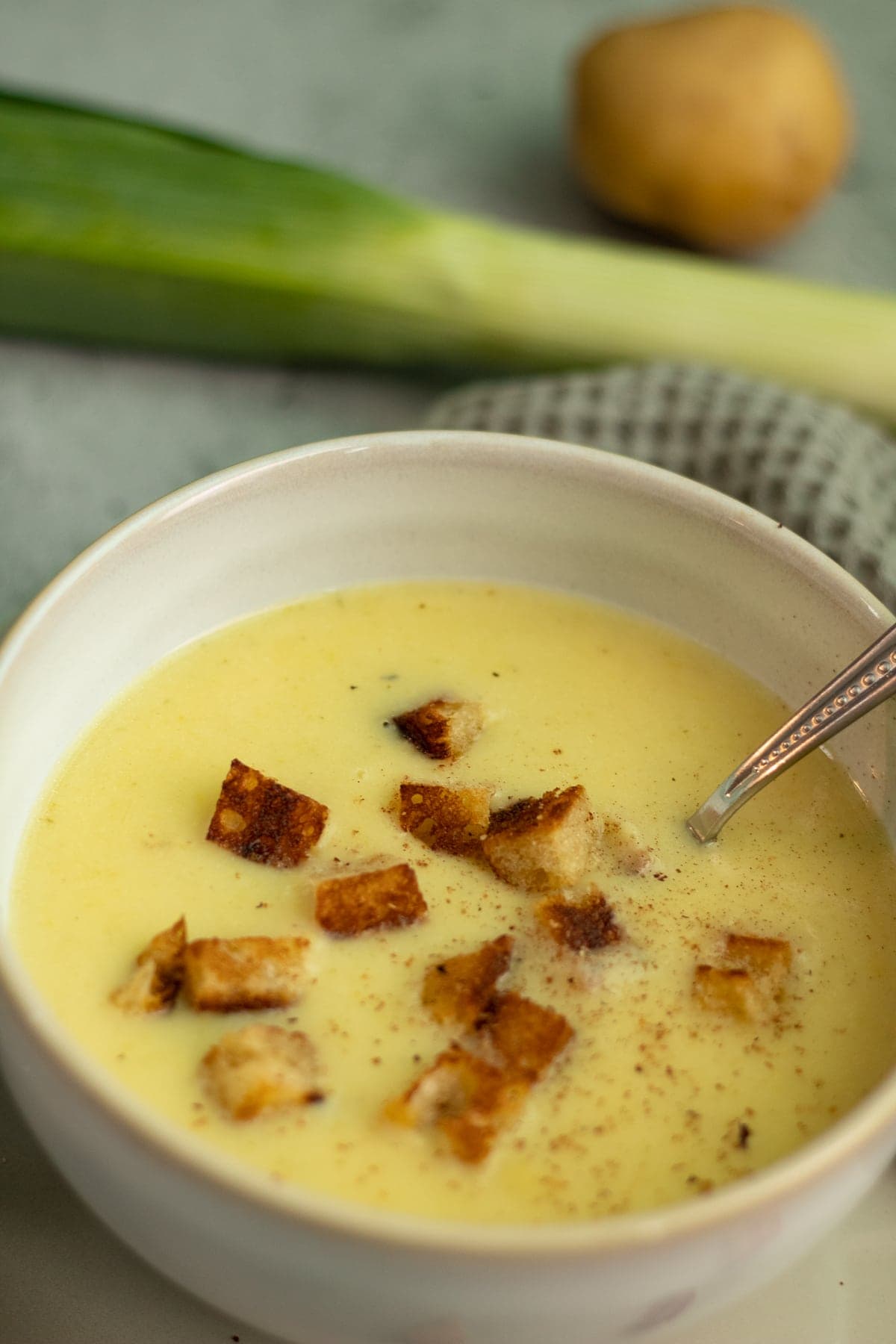 bowl of soup with a spoon in it and croutons