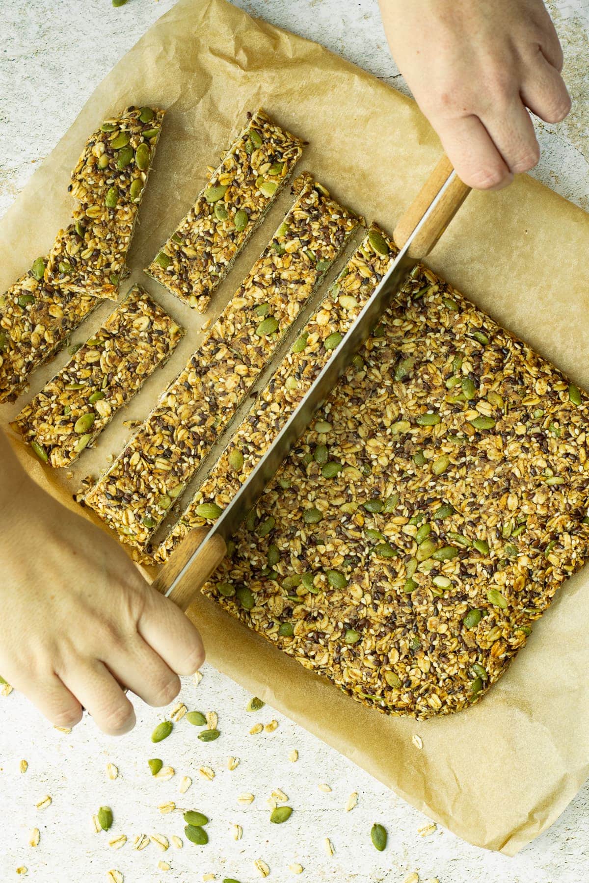Hands cutting granola bars with a large cutter