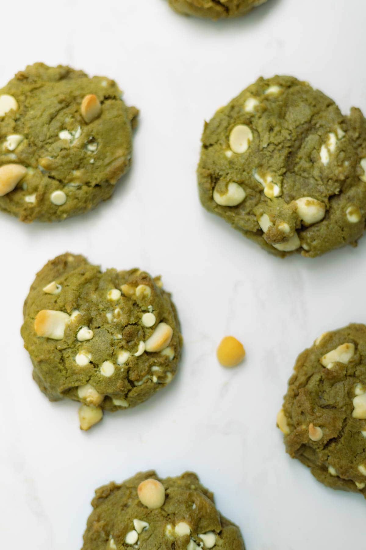 Matcha cookies with white cholate chips on white marble background